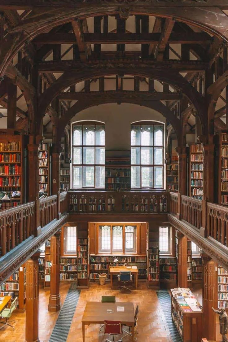 the inside of a library with many bookshelves and tables on each side of the room