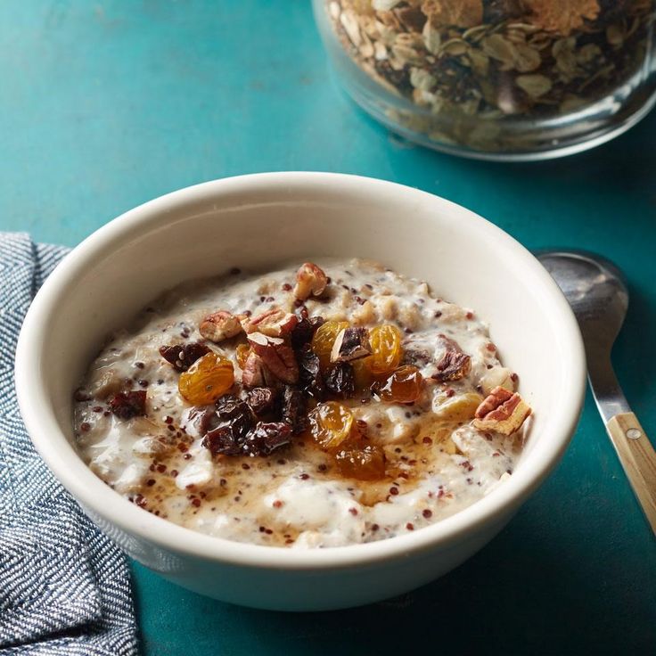 a bowl of oatmeal with nuts and raisins on the side