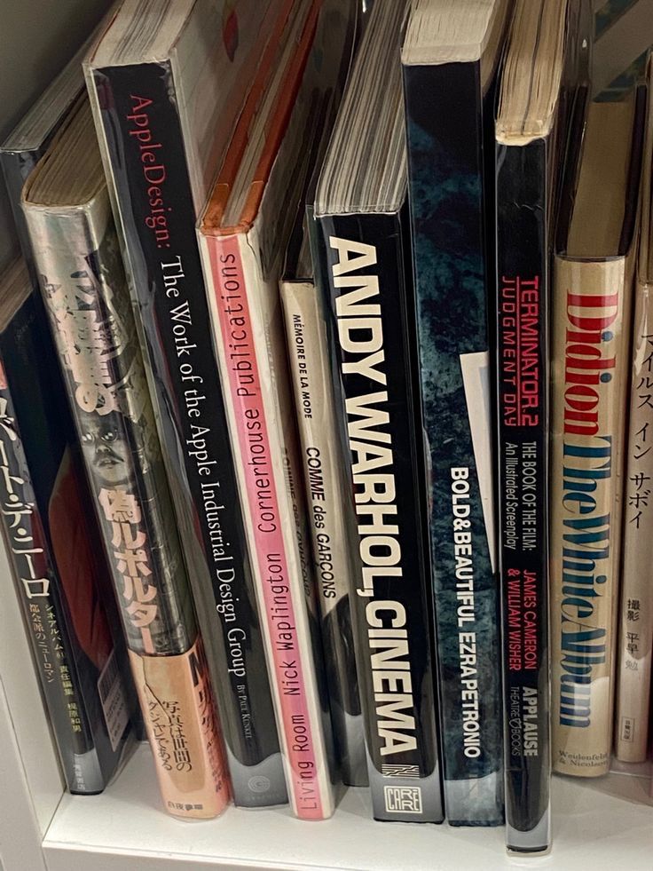 a book shelf filled with lots of books on top of white shelves next to each other