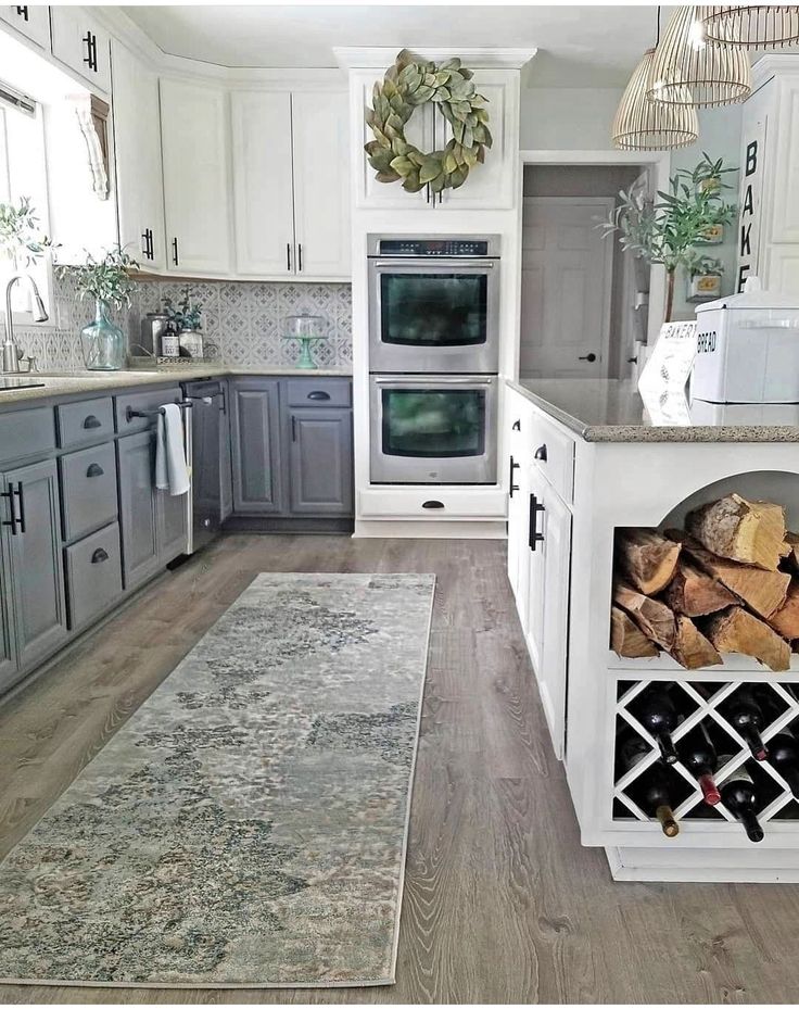 a kitchen with white cabinets and wood stacked on top of each other in front of an oven