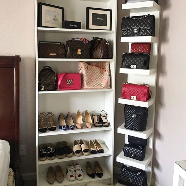 a closet filled with lots of purses and handbags next to a wall mounted shelf