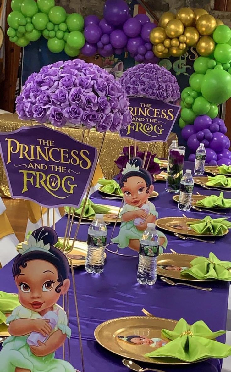 the princess and the frog party table set up with plates, napkins and balloons