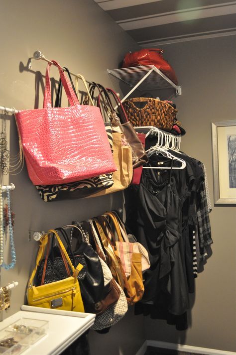 a closet with several purses and handbags hanging on the wall next to it