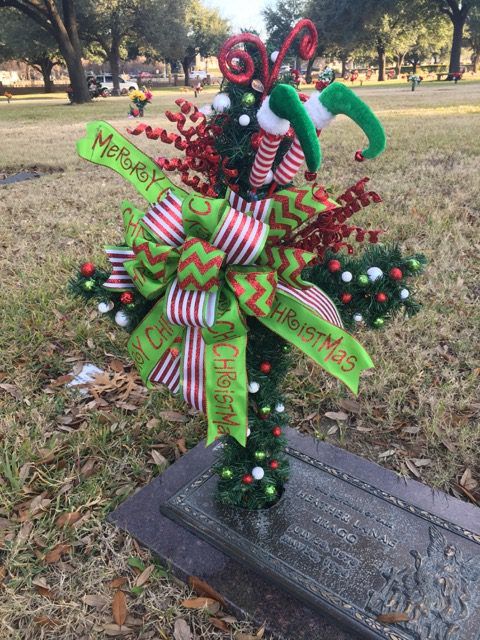 a christmas wreath with candy canes on it in the middle of a grave marker