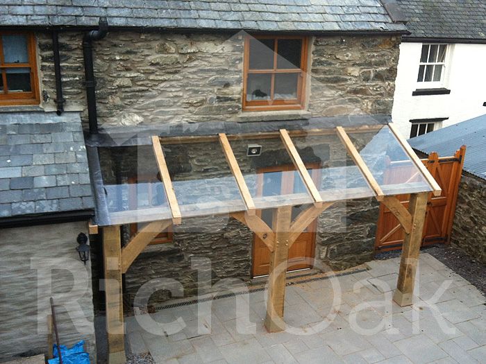 a house that is made out of wood and stone with a glass door on the outside