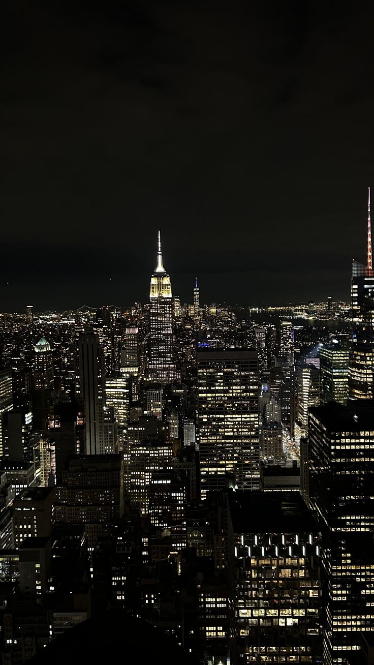 an aerial view of the city at night with skyscrapers lit up in bright colors