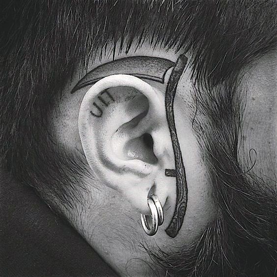 a man with ear piercings on top of his head and behind the ear is a clock