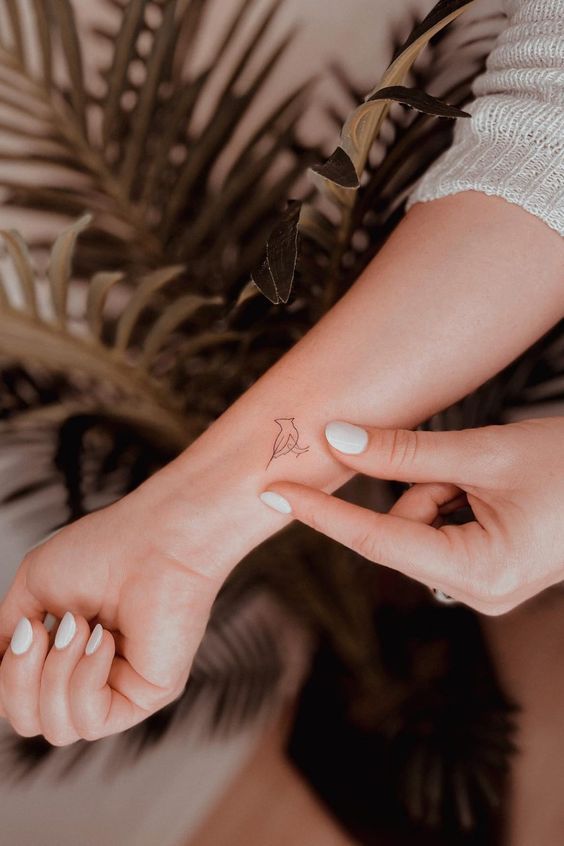 a woman's hand with a small tattoo on it