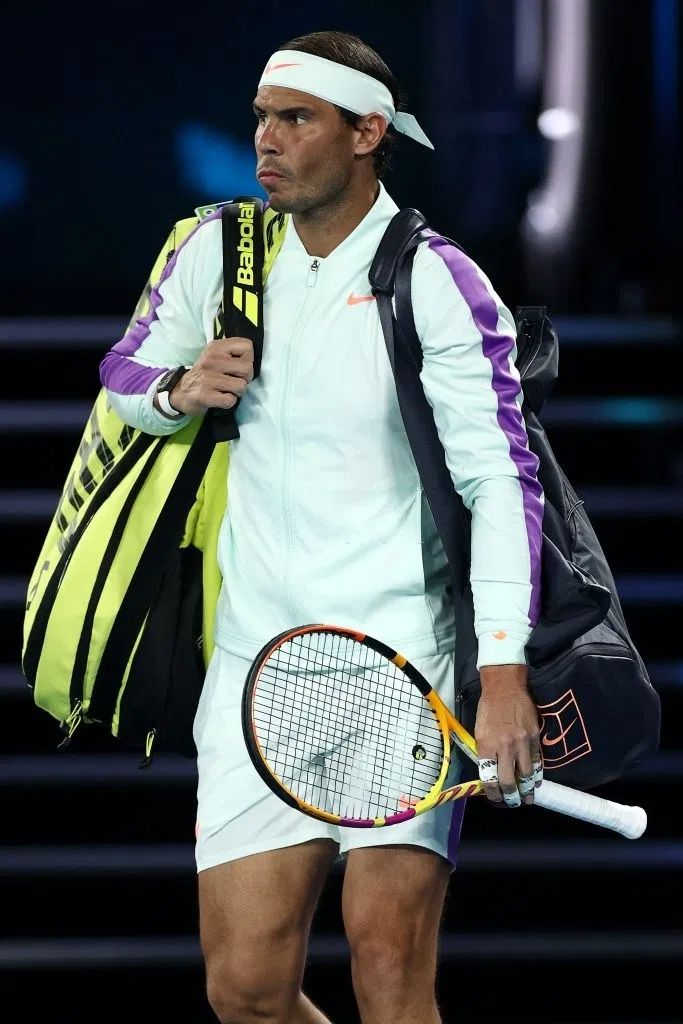 a male tennis player with a racket in his hand and a bag on his shoulder