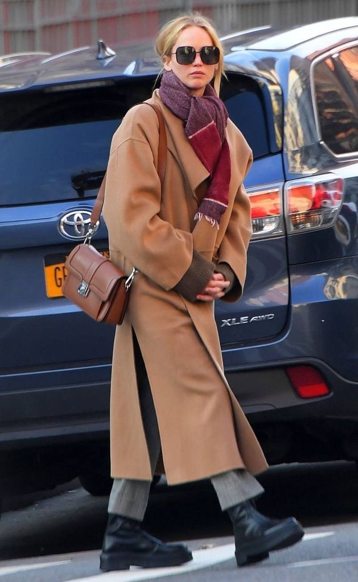 a woman walking down the street in winter clothes