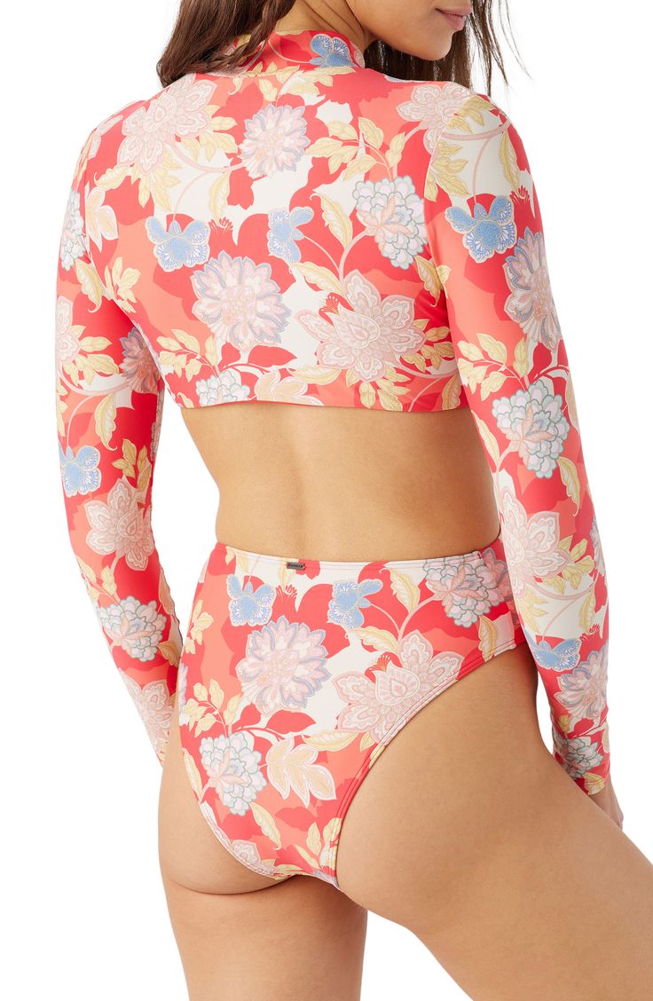 Tropical blooms brings vacation-ready style to this long-sleeve one-piece with sunny waist cutouts. Front zip closure Mock neck Long sleeves Moderate back coverage 85% recycled polyester, 15% elastane Hand wash, dry flat Imported lined Long Sleeve Tops For Pool And Spring, Long Sleeve Tops For Pool And Beach Season, Long Sleeve Swimwear For Beach Season, Long Sleeve Floral Print Stretch Swimwear, Trendy Long Sleeve Swimwear For Spring, Beachy Long Sleeve Tops For Poolside, Long Sleeve Swimwear For Poolside In Summer, Summer Long Sleeve Swimwear For Beach Season, Long Sleeve Floral Print Swimwear For Surfing