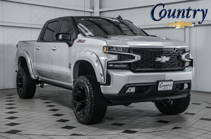 a silver truck parked in a garage with the words country on it's side