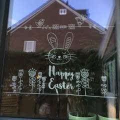 the window is decorated with an image of a bunny on it's face and words that say happy easter