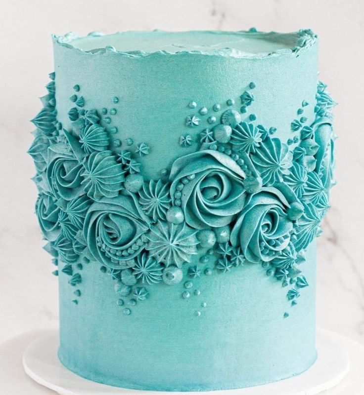 there is a blue cake with flowers on it