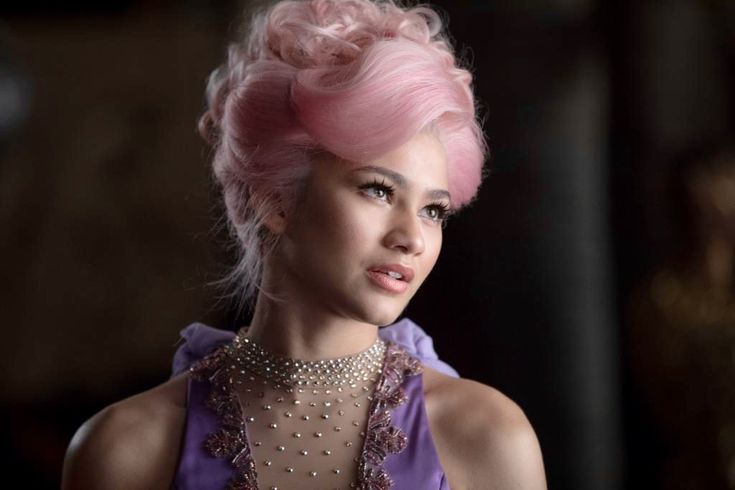 a woman with pink hair is wearing a purple dress and pearls on her neckline