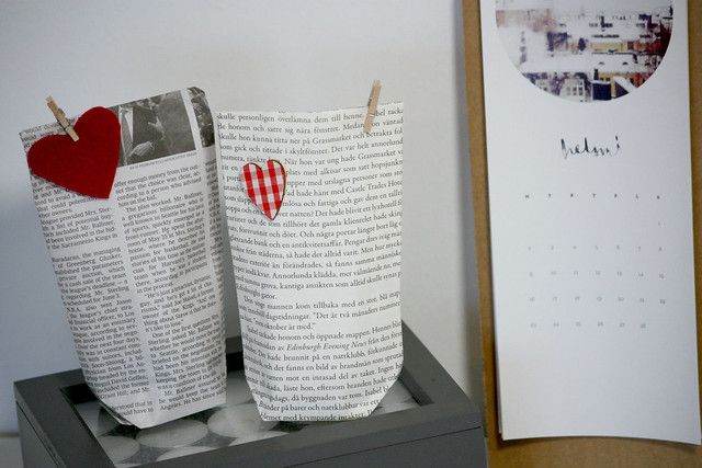 two paper bags with hearts on them are sitting on a shelf next to a calendar