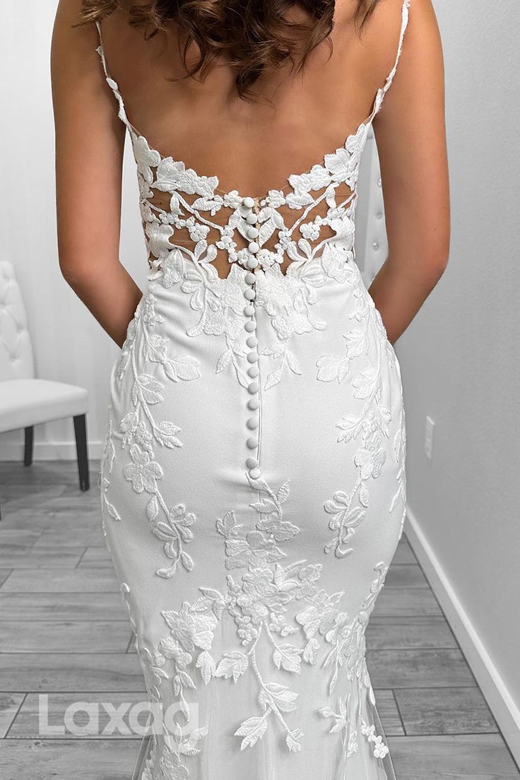 the back of a woman's white wedding dress with floral appliques on it