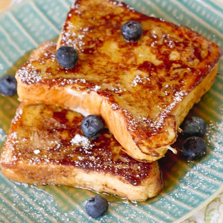 two pieces of french toast on a plate with blueberries