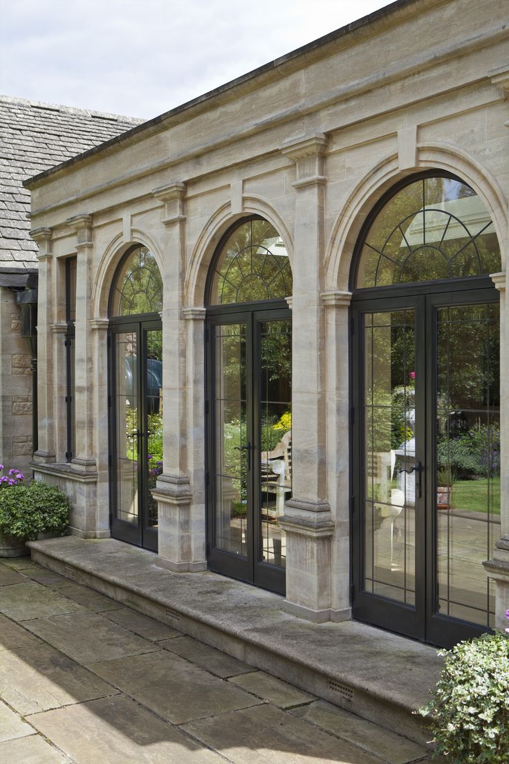 an outside view of a house with many windows and doors on the side of it