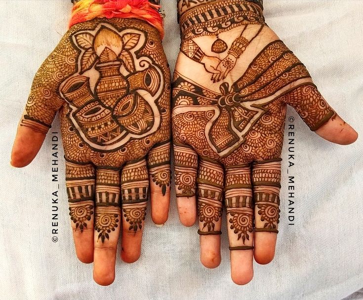 two hands decorated with henna designs on top of each other and an orange flower in the middle