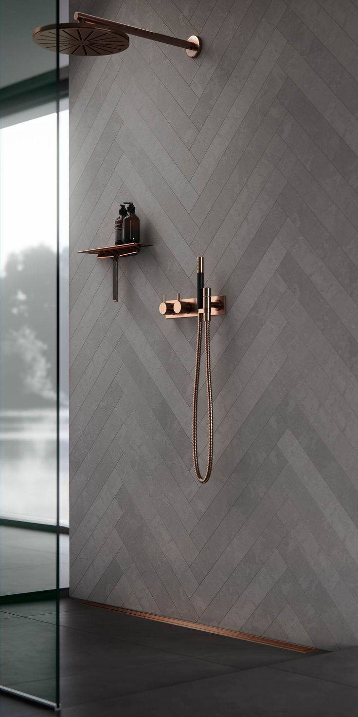 a bathroom with a shower head and hand held shower faucet in the wall