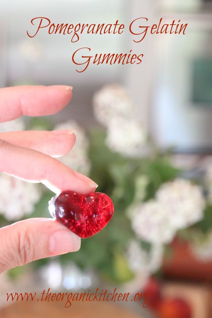 a person holding a heart shaped object in their hand with the caption, pomegranate gelatin gummies