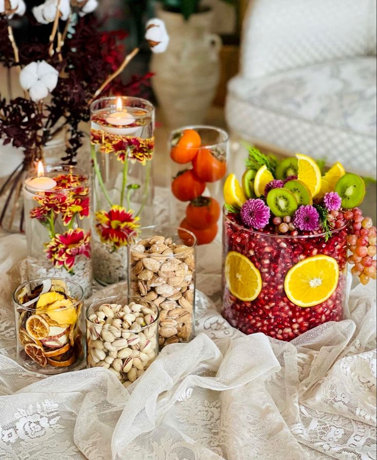 a table topped with vases filled with different types of fruit and veggies