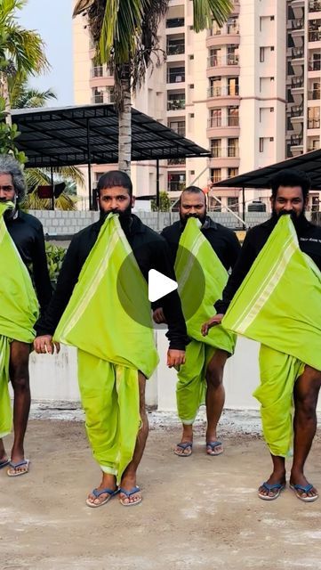 five men in black and green outfits holding up kites with palm trees in the background