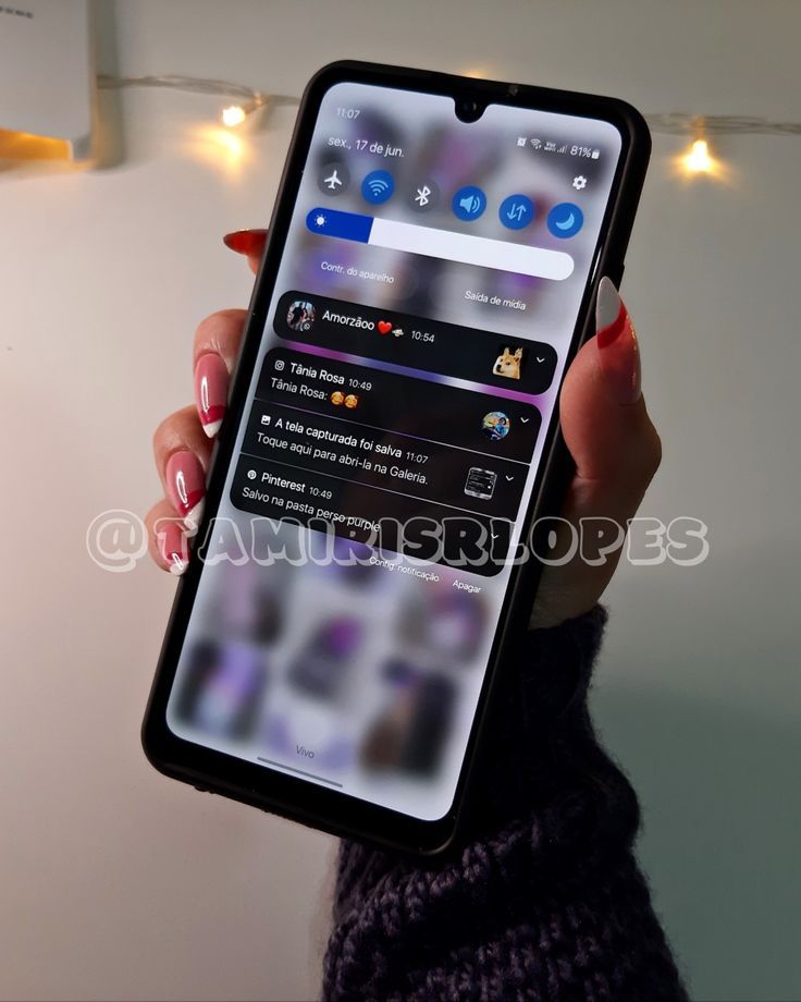 a woman holding up her cell phone with the app on it's display screen