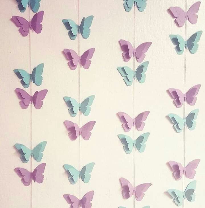 there are many butterflies hanging on the wall and one is blue with purple in it