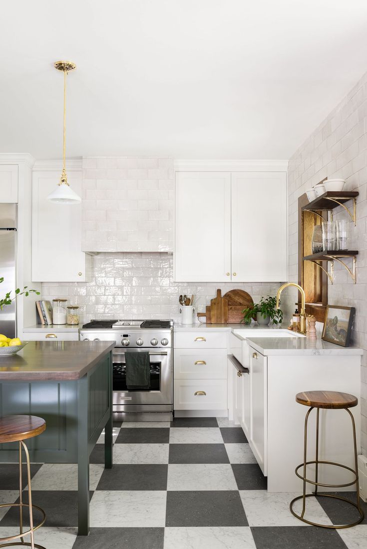 a black and white checkered floor in a kitchen with two stools next to the island