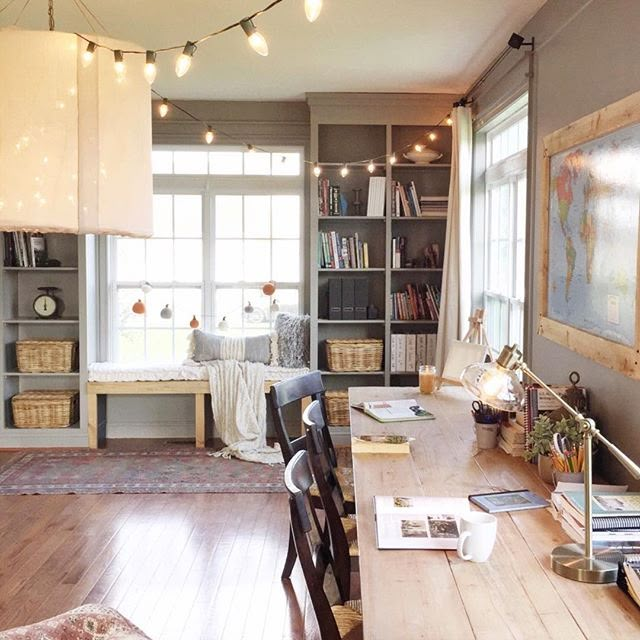 a living room filled with furniture and lots of books on top of a wooden table