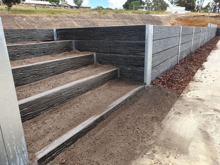 the steps are made out of wood and concrete, along with mulch on the ground