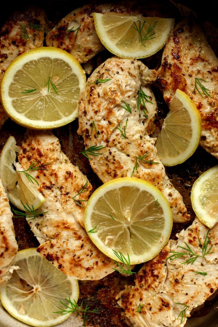 chicken with lemons and herbs in a pan