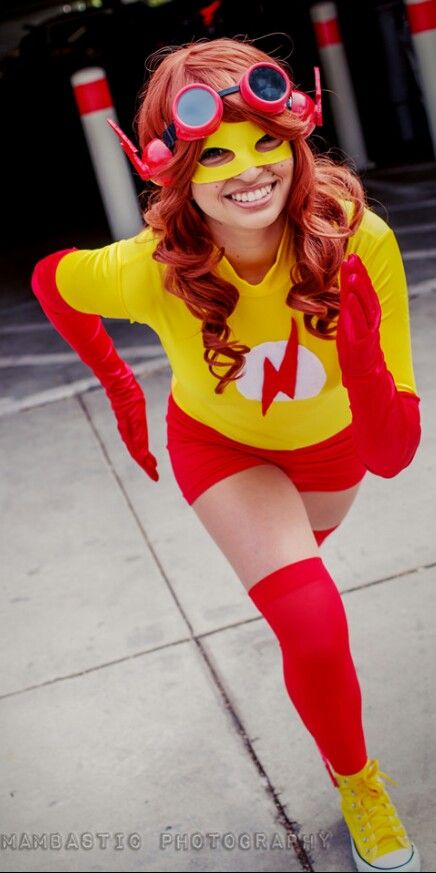 a woman in a yellow and red costume poses for the camera with her hands on her hips