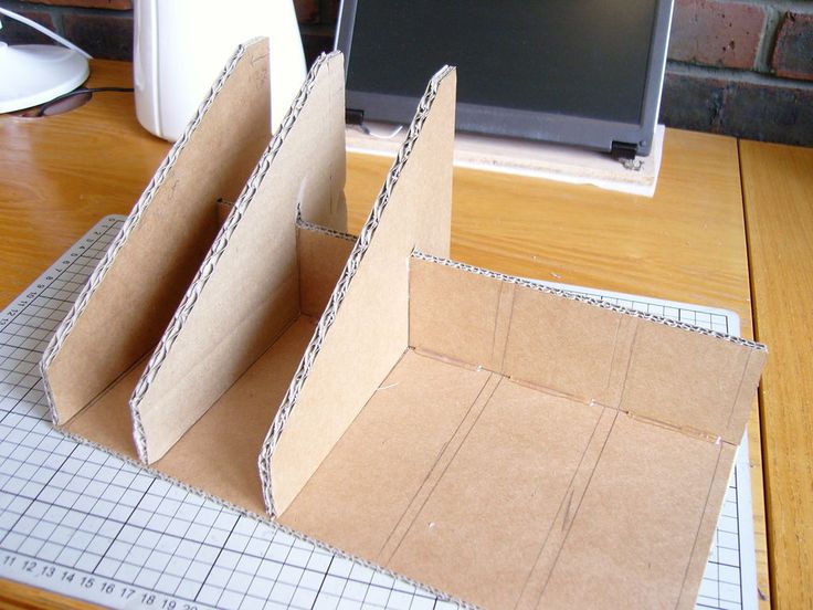 an open cardboard box sitting on top of a wooden table next to a computer monitor