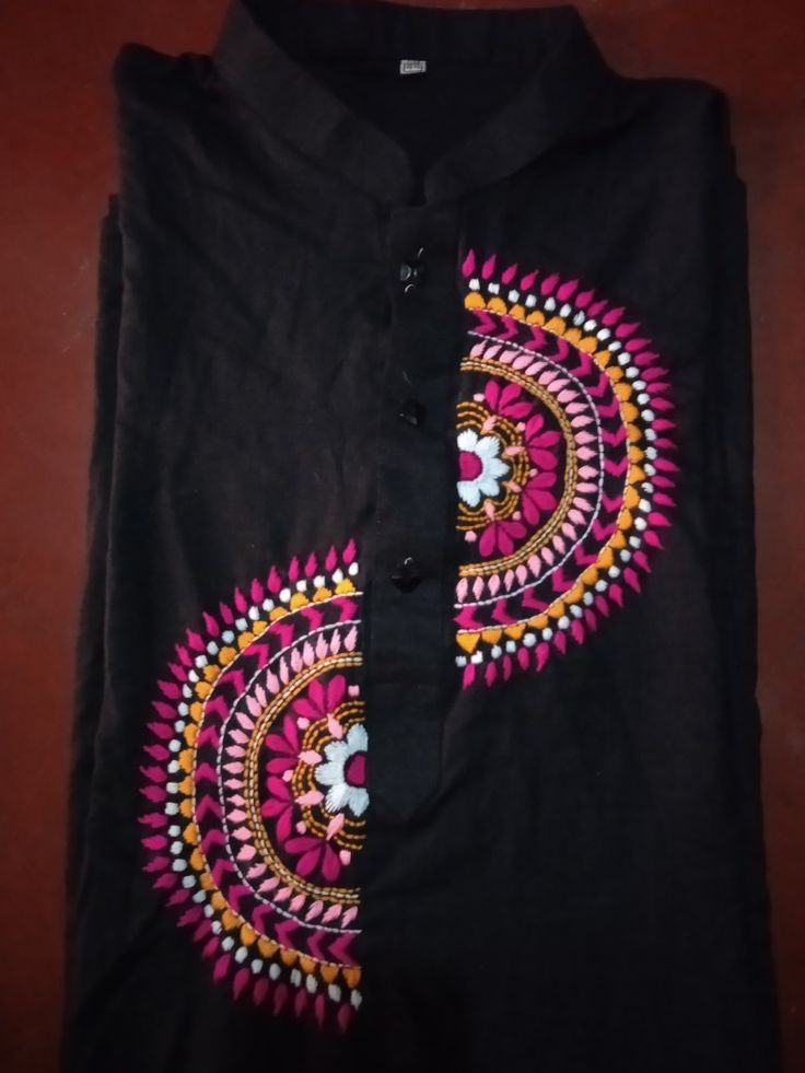 a black shirt with colorful designs on it