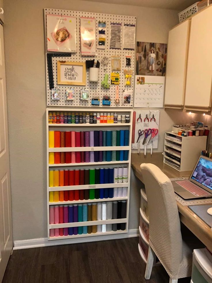 a craft room filled with lots of craft supplies and crafts on the wall next to a desk