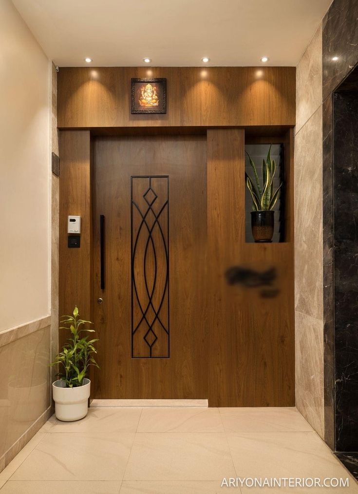 a modern entry way with wood paneling and metal accents on the door, along with a potted plant