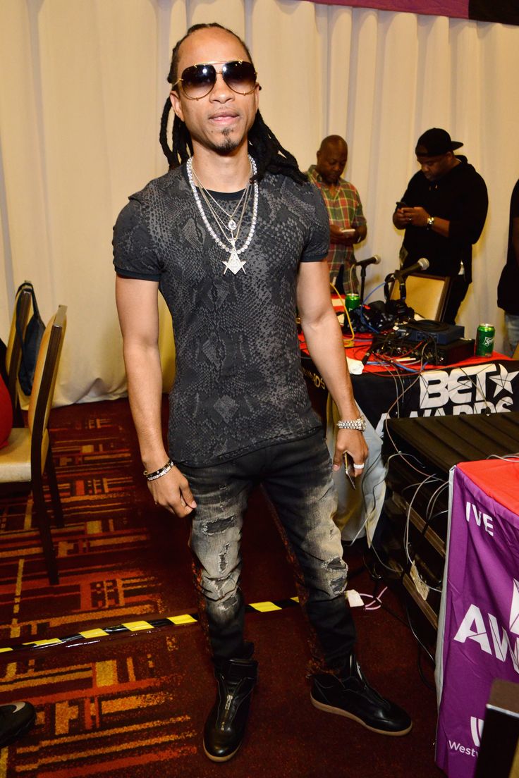 a man with dreadlocks standing in front of a table