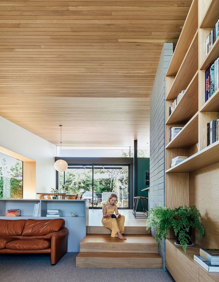 an image of a living room with stairs and bookshelves on the wall above