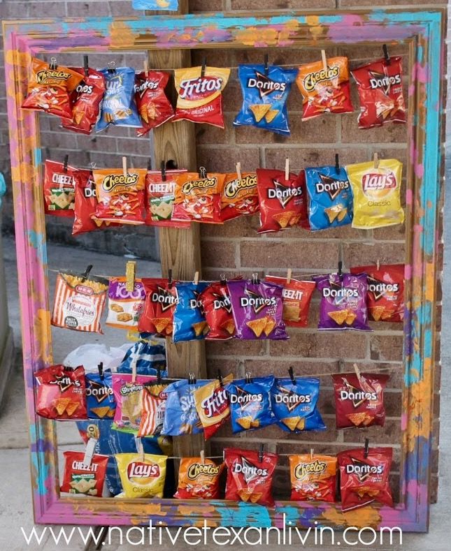 a colorful display with candy bags hanging from it's sides on a brick wall