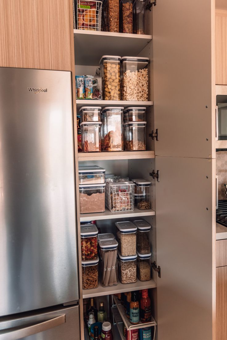 an organized pantry in a kitchen with stainless steel appliances