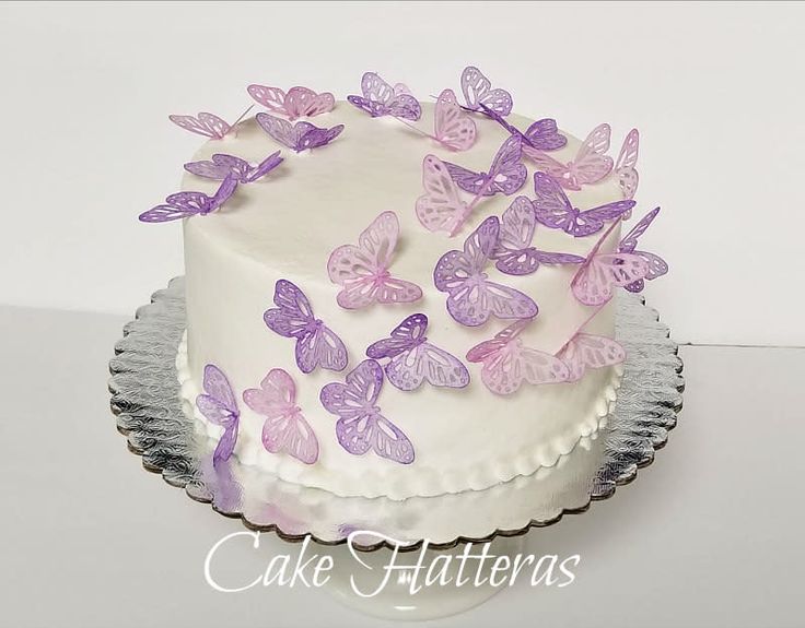 a white cake with purple butterflies on it