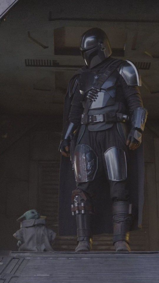 the star wars character is dressed in armor and standing on a platform with his hands behind his back