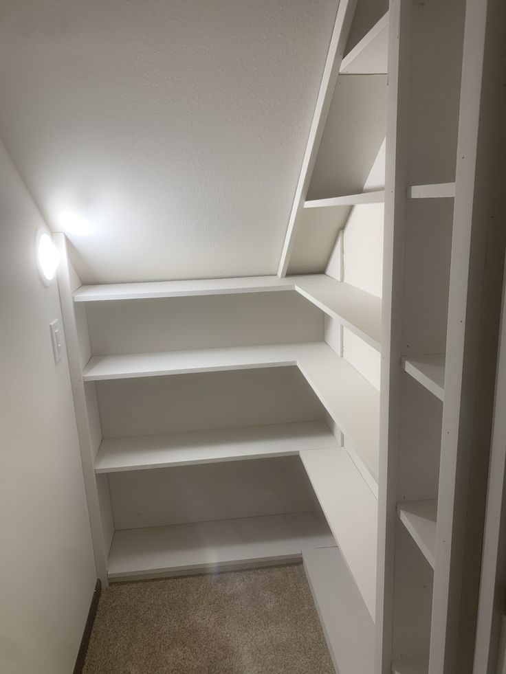 an empty white closet with shelves and lights