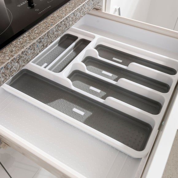 the trays are sitting on the counter in front of the stove top burner