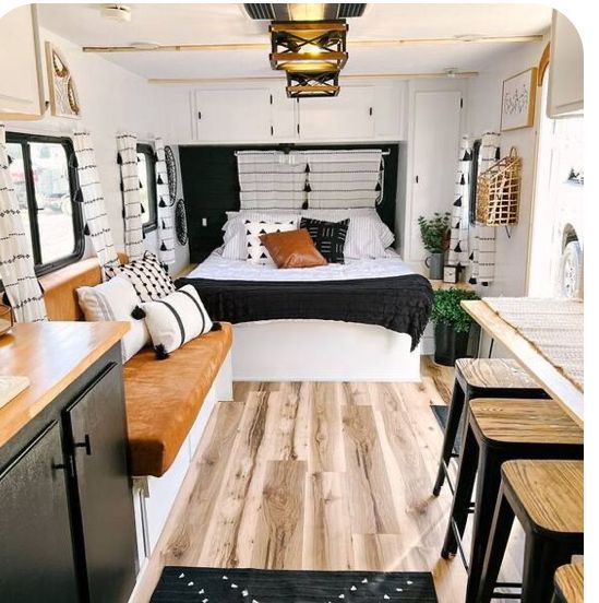 a bed sitting in the middle of a room next to a kitchen and dining area