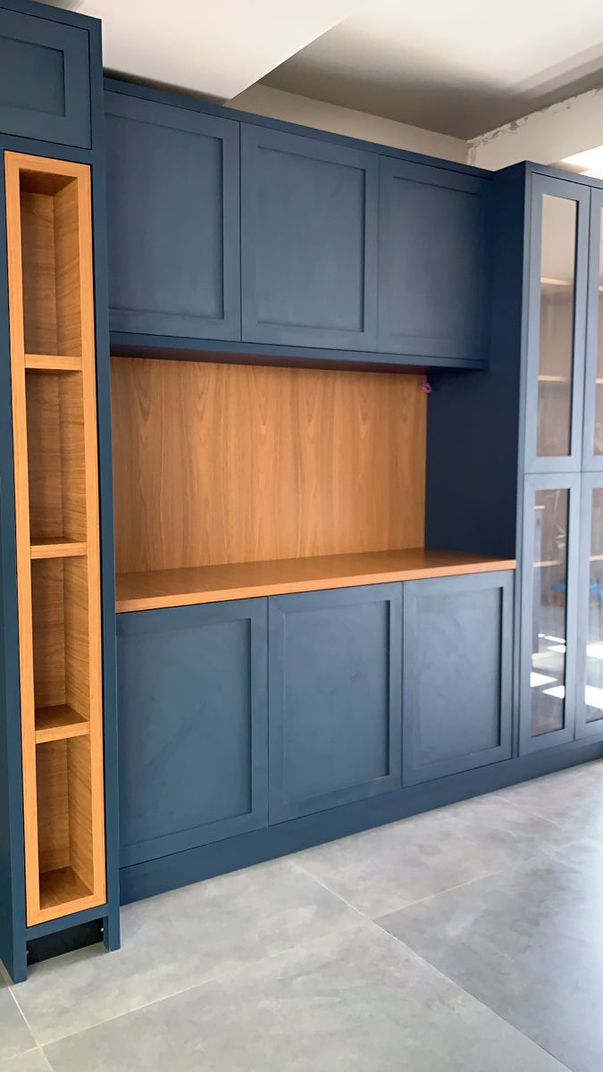 an empty room with blue cabinets and wooden shelves