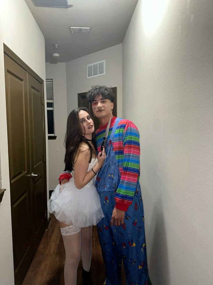 a man and woman dressed up in costumes standing next to each other on a hallway